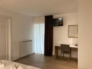 a hotel room with a desk and a window at B&B La casa dei nonni Assergi in Assergi