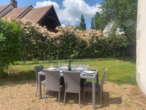 - une table et des chaises dans une cour avec un jardin dans l'établissement Maison tourangelle au coeur du vignoble Loire Valley, à Vouvray