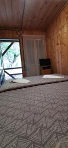 a large bed in a room with a window at La Cabana in Băile Herculane