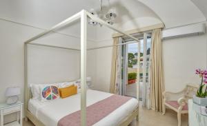 a bedroom with a canopy bed and a balcony at Villa Giardini Luxury Room in Capri