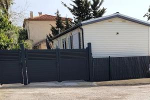 una puerta negra frente a una casa con garaje en Mobil home de Patricia et Franck à Sigean, en Sigean