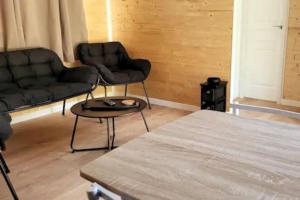 a living room with two couches and a table at Mobil home de Patricia et Franck à Sigean in Sigean