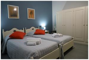 a bedroom with two beds with red and white pillows at CASA DIDYMA in San Giovanni Gemini