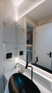 W łazience znajduje się czarna umywalka i lustro. w obiekcie Pousada Água Marinha w mieście Cabo Frio