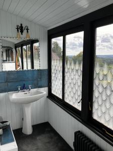 un bagno con lavandino e due finestre di Shaftesbury Centre a Shaftesbury