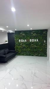 a green wall in a room with a couch at Love room borabora in Reyrieux