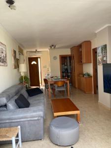 sala de estar con sofá y mesa en Acogedor apartamento en la Playa. Urbanización La Felicidad. Las Marinas en Dénia