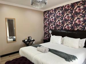 a bedroom with a large bed with a floral wallpaper at Thabazimbi Country Lodge in Thabazimbi