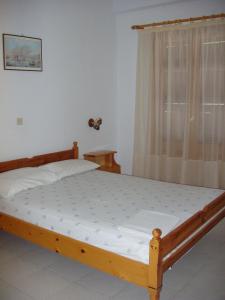 KómboiにあるKombi Beachのベッドルーム1室(木製ベッド1台、窓付)