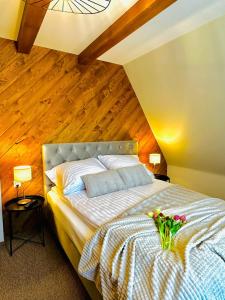- une chambre avec un grand lit et un plafond en bois dans l'établissement River ApartHouse Zakopane, à Zakopane