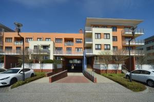 un edificio con coches estacionados frente a él en Apartamenty Sun Seasons 24 - Zielone Tarasy, en Kołobrzeg