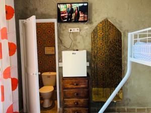 uma casa de banho com WC e uma televisão na parede em Laurentissime em Saint-Laurent-du-Var