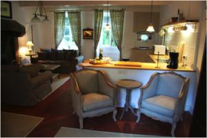 a living room with two chairs and a counter top at Chateau de Villette in Poil