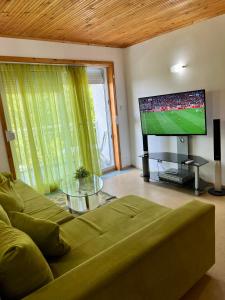 sala de estar con sofá y TV de pantalla plana en Villa MAXIMILIYAN, en Albena