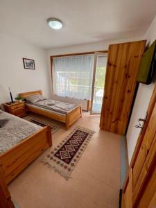 1 dormitorio con 2 camas y puerta corredera de cristal en Villa MAXIMILIYAN, en Albena