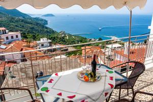a table with a bottle of wine on a balcony at Anna's House in Glossa