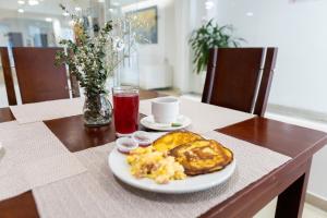 a plate of breakfast food on a wooden table at Hotel Ayenda 1316 Charthon Barranquilla in Barranquilla