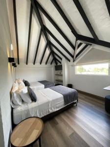 a bedroom with two beds and a table at Hotel Santiago de Arma in Rionegro