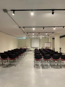 an empty room with chairs and a screen and a podium at Hotel Santiago de Arma in Rionegro