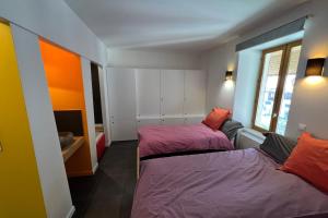 sypialnia z 2 łóżkami i oknem w obiekcie Le Postillon Quinto w mieście Entremont-le-Vieux