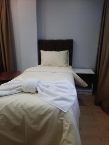 ein Bett mit weißer Bettwäsche und Kissen in einem Schlafzimmer in der Unterkunft Eyüpsultan ABS Suites in Istanbul