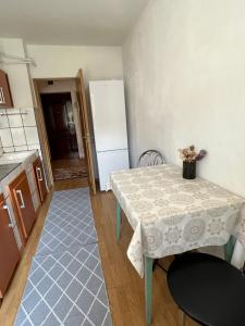 uma cozinha com uma mesa e um frigorífico em Apartament centru em Râmnicu Vâlcea
