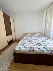 a bedroom with a bed with a floral comforter at Apartament centru in Râmnicu Vâlcea