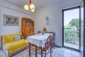 a dining room with a table and chairs and a couch at Apartment Valnea in Poreč