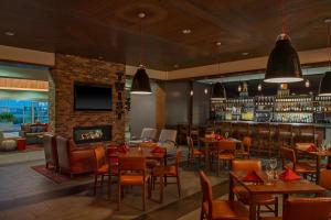 a restaurant with tables and chairs and a fireplace at Four Points by Sheraton Midland in Midland