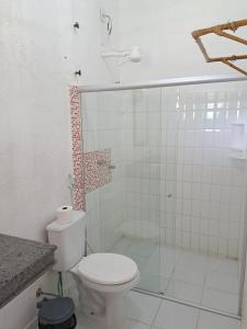 ein weißes Bad mit einem WC und einer Dusche in der Unterkunft Pousada Éden Rio in Ilhéus