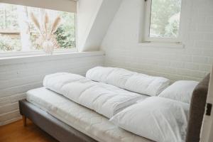 una fila di cuscini in una stanza con finestra di Boshuisje Rekem - Boris a Lanaken