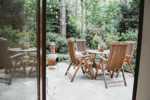 una mesa de madera y sillas en un patio en Boshuisje Rekem - Boris en Lanaken