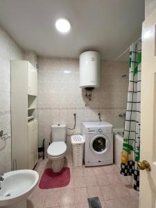 een badkamer met een toilet en een wasmachine bij Lamada Family Two Bedroom Apartment in Budva