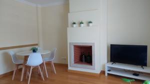 a living room with a table and a fireplace at Sesimbra TOP in Sesimbra