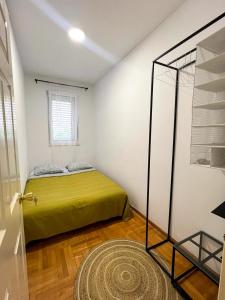 een slaapkamer met een groen bed en een raam bij Lamada Family Two Bedroom Apartment in Budva