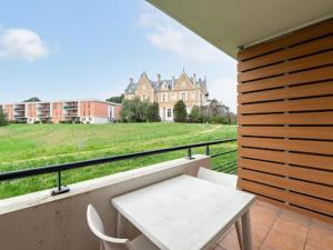 balcón con mesa y vistas a un edificio en Studio residence de tourisme le Fonserane, en Béziers