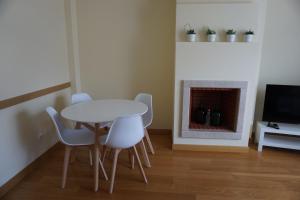 a dining room with a table and chairs and a fireplace at Sesimbra TOP in Sesimbra