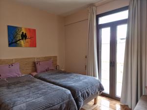 a bedroom with two beds and a sliding glass door at LIBERTY ΙΩΑΝΝΙΝΑ in Ioannina