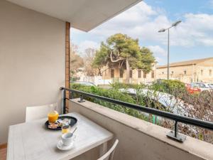 un balcón con una mesa con comida y bebidas. en Studio residence de tourisme le Fonserane, en Béziers