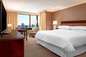 a hotel room with a bed and a large window at Sheraton Centre Toronto Hotel in Toronto