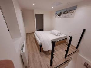 a small bedroom with a bed and a mirror at Maisonnette à 1 km de la plage in Berck-sur-Mer