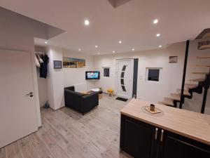 a living room with a couch and a living room with stairs at Maisonnette à 1 km de la plage in Berck-sur-Mer