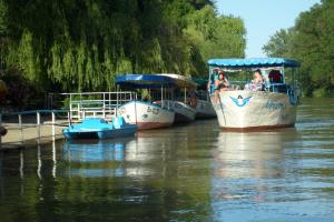 three boats docked on a river with people on them at Апартамент в Oasis beach Kamchia - Стъпки в пясъка in Kamchia