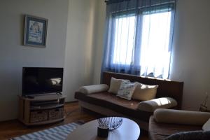 a living room with a couch and a tv at Апартамент в Oasis beach Kamchia - Стъпки в пясъка in Kamchia