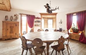 una sala da pranzo con tavolo e sedie in legno di Top of the World Apartment a Sankt Moritz