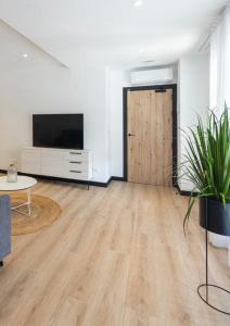 a living room with a wooden floor and a sliding door at DONOSTIA ROOMS in San Sebastián