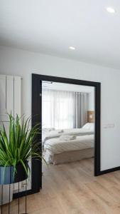 a large mirror in a bedroom with a bed at DONOSTIA ROOMS in San Sebastián