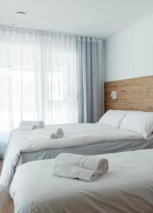 2 letti in camera d'albergo con asciugamani di DONOSTIA ROOMS a San Sebastián