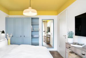 um quarto com uma cama branca e um tecto amarelo em Seehuus Duhnen Apartments em Cuxhaven
