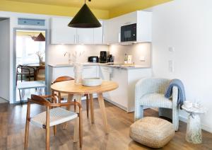 Seehuus Duhnen Apartments في كوكسهافن: مطبخ وغرفة طعام مع طاولة وكراسي